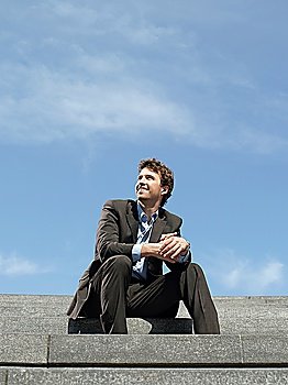 Businessman sitting on steps outdoors low angle view
