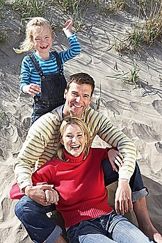 Parents with daughter (5-6) on beach portrait