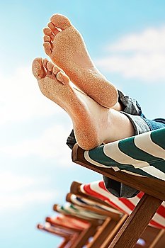 Person resting on deckchair on beach low section close up of feet