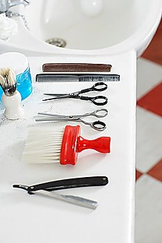 Scissors combs razor and brush on counter in barber shop