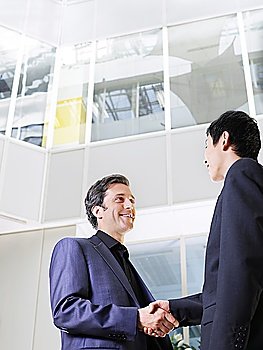 Two business men shaking hands low angle view
