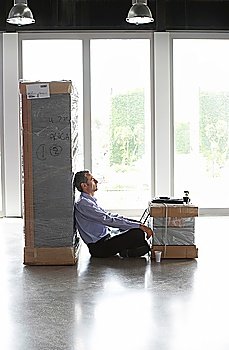 Overworked Businessman Sitting Between Two Packages