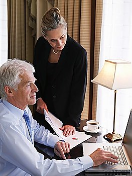 Businessman and Woman Working on Laptop