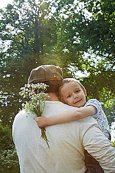 Father Carrying Daughter Holding Wildflower Bouquet