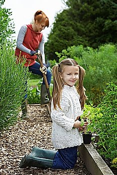 Girl (5-6) gardening with mother in countryside