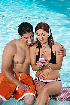 Young Couple with Mp3 Player, Relaxing at Swimming Pool