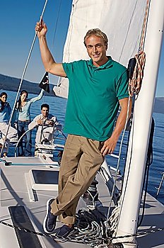 Man Standing on Sailboat with Friends