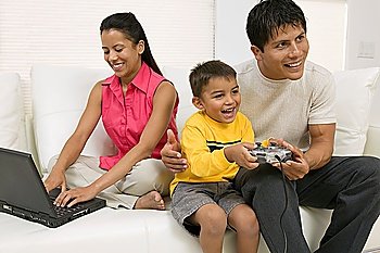 Family Playing Video Game and Using Computer on Couch