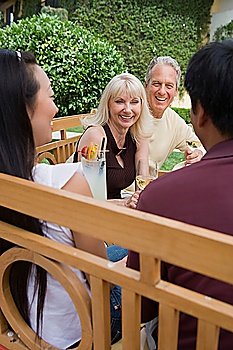 Two couples drinking wine in garden
