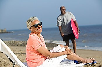 Middle-aged woman sitting on a deckchair on a beach