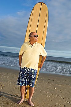 Senior man holding a surfboard