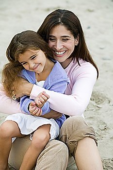 Mother embracing daughter on beach