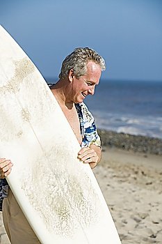 Middle-aged man holding a surfboard