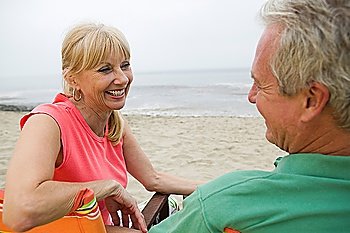Middle-aged couple sitting on beach