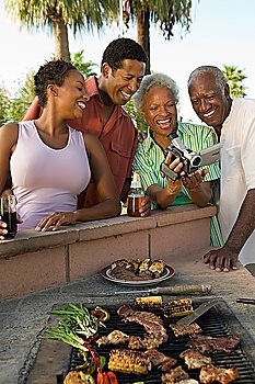 Family Looking at Video Camera During Barbecue
