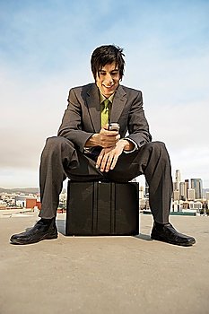 Businessman Sitting on Briefcase