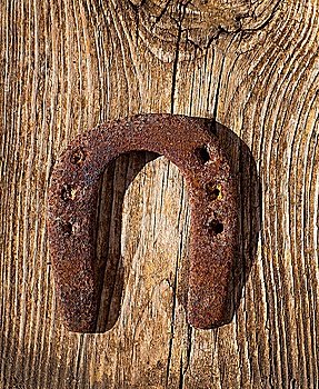 Antique horseshoe luck symbol rusted on vintage wood background