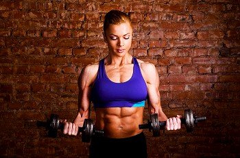 strong woman is training with barbells