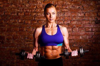 strong woman is training with barbells