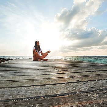 Yoga woman meditating near sea
