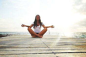 Yoga woman meditating near sea