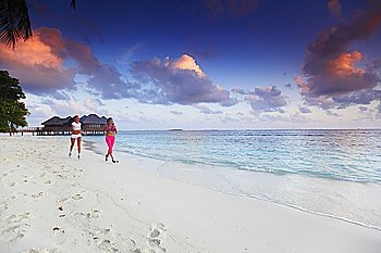 Two women running on beach