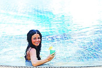 Woman in swimming pool with cocktail
