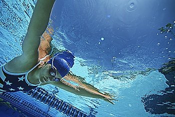 Female swimmer wearing United States swimsuit, swimming in pool