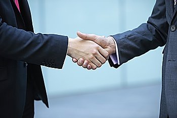 Mid section of business people shaking hands