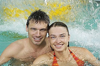 Young couple in swimming pool, portrait