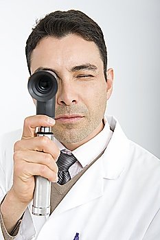 Optician looks through sight testing equipment