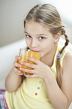 Portrait of little girl drinking orange juice
