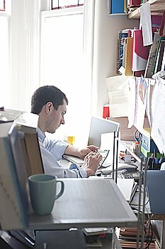 Mid adult man with calculator in home office