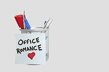 Conceptual image of sticky notepaper with heart shape depicting office romance