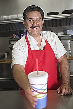 Portrait of man serving drink in restaurant