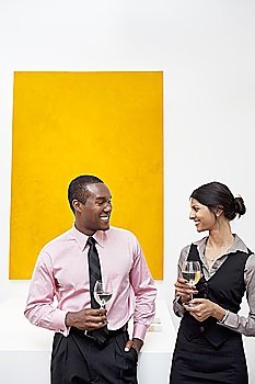 Two young executives in front of yellow painting