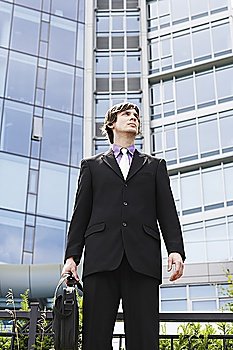 Business man holding briefcase, outside office