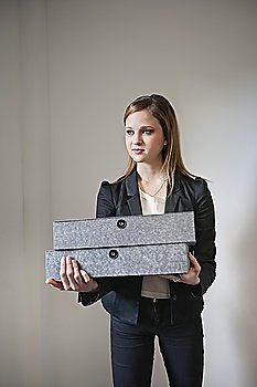 Young businesswoman holding box file