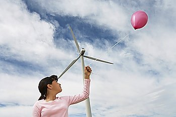 Girl (7-9) playing with balloon at wind farm