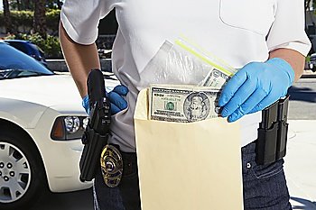 Police Officer Putting Money in Evidence Envelope