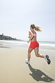 Woman jogging along beach