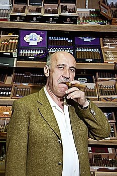 Portrait of a mature man smoking cigar in tobacco store