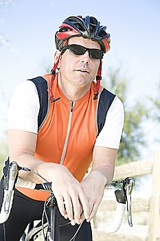 Male cyclist leans on handlebars