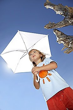 Boy (7-9) holding beach umbrella, view from below