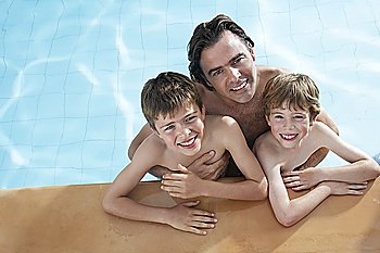 Portrait of father with two sons (5-11) in swimming pool, elevated view