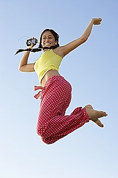 Young woman jumping with mp3 player in hand