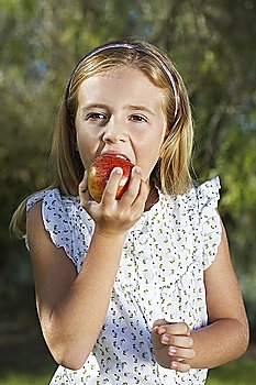 Portrait of girl (5-6) eating apple