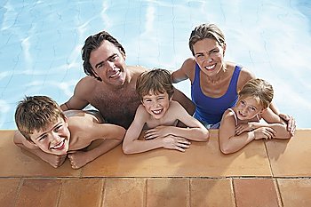 Portrait of family with three children (5-11) in swimming pool, smiling