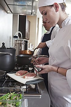Young chef preparing raw meat