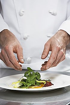 Male chef preparing salad, mid section